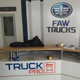 Вывеска FAW Trucks и логотип на стойке ресепшн
